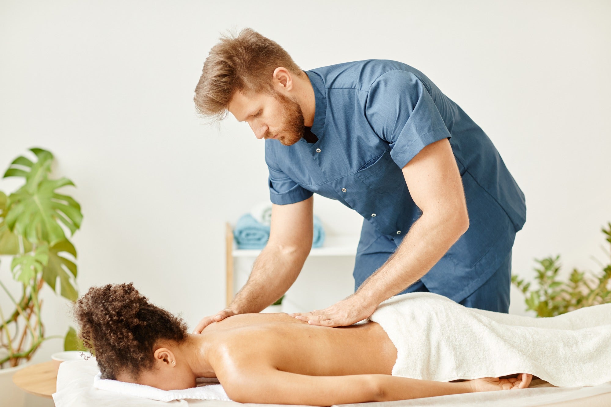 Home spa session: Woman enjoying a massage therapy at home to represent a massage therapist carreer